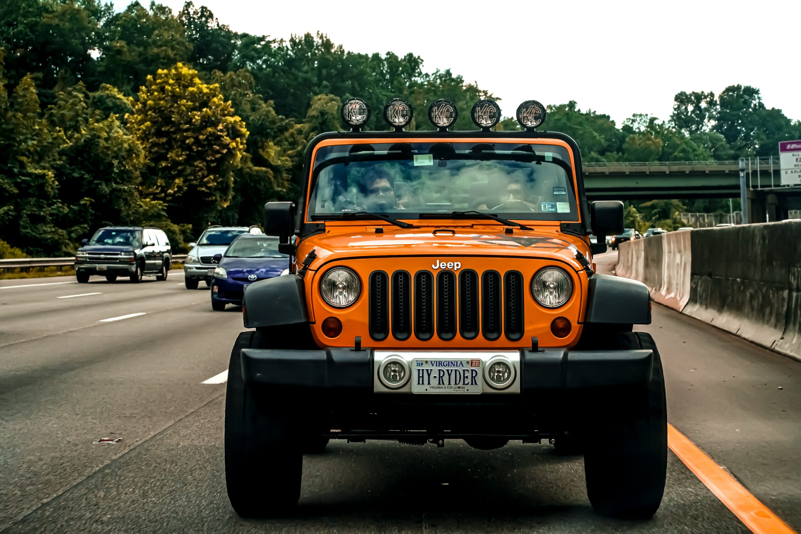 An orange Jeep heading to a Jeep Lemon Lawyer