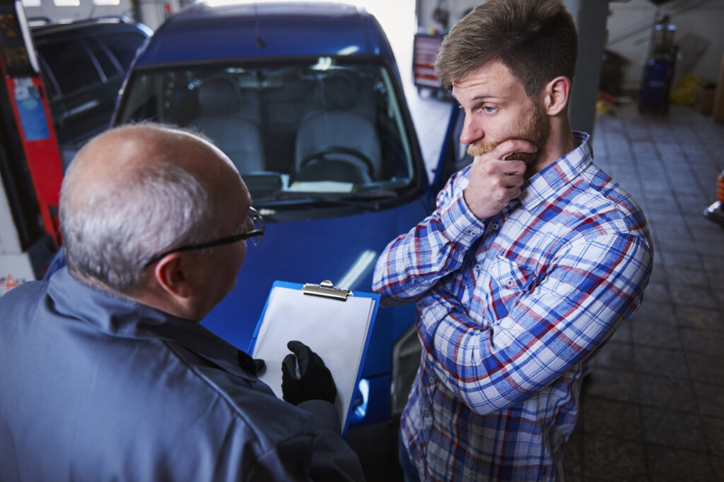 Hombre consultando a un mecánico sobre su jeep
